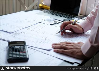 architect engineer working on house blueprint of real estate project at workplace. construction & building double exposure with crane