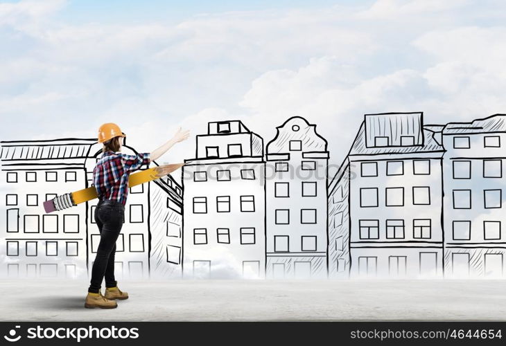 Architect female designer. Young female engineer in hard hat with big pencil and buildings sketches at background