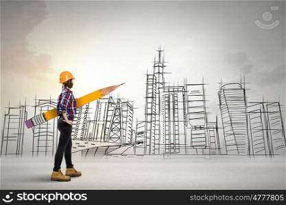 Architect female designer. Young female engineer in hard hat with big pencil and buildings sketches at background