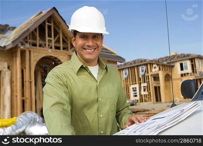 Architect holding blueprints on construction site