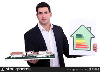 Architect holding model housing and energy rating panel