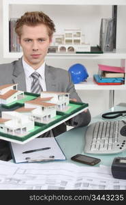 Architect holding up a building model