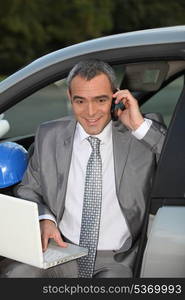 Architect in car speaking on mobile telephone