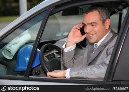 Architect in car using mobile telephone