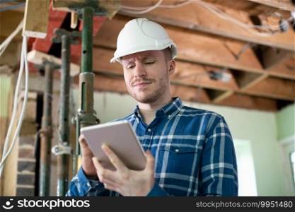 Architect Inside House Being Renovated Using Digital Tablet