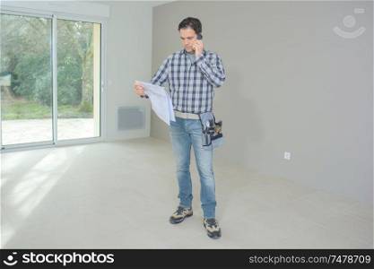 architect inspecting a blueprint while at the construction site