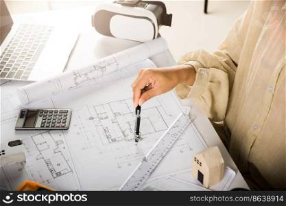 Architect interior design drawing with divider compass on house plan blueprint paper for editing on table desk at architecture office, Engineer sketching construction, Architectural project workplace