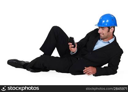Architect laying on the floor with mobile