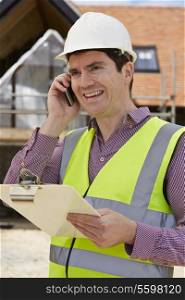 Architect On Building Site Using Mobile Phone