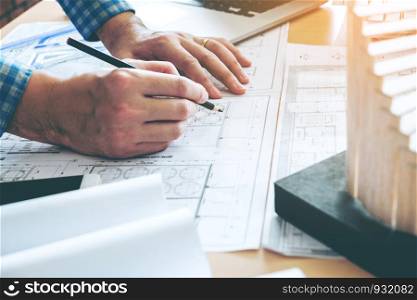 Architect or engineer working in office on blueprint. Architects workplace