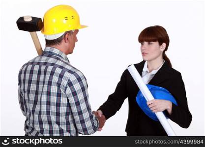 Architect shaking hands with a construction worker