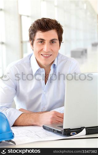 Architect sitting in front of laptop computer