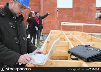 Architect stood by wooden frame