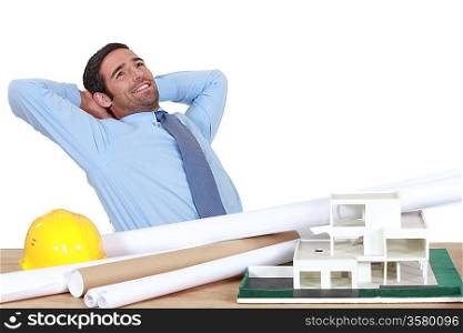 Architect stretching at his desk