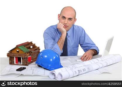 Architect with plans and model of a log cabin