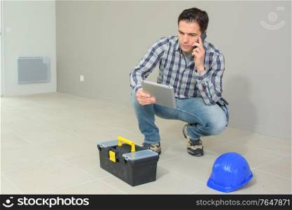 architect working on construction site talking on the phone