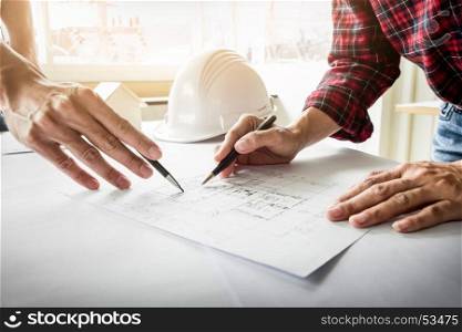 Architects engineer discussing at the table with blueprint - Closeup on hands and project print
