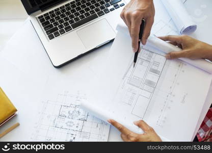 Architects engineer discussing at the table with blueprint - Closeup on hands and project print.