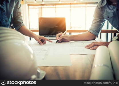 Architects engineer discussing at the table with blueprint - Closeup on hands and project print.