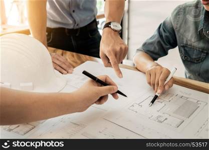 Architects engineer discussing at the table with blueprint - Closeup on hands and project print.