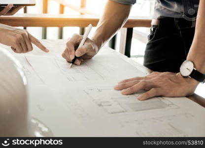 Architects engineer discussing at the table with blueprint - Closeup on hands and project print.