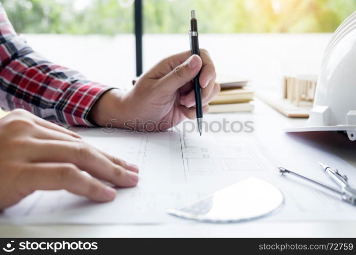 Architects engineer discussing at the table with blueprint - Closeup on hands and project print.