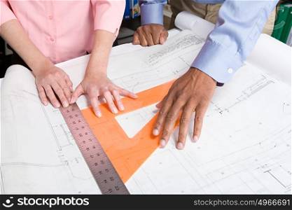 Architects measuring blueprint