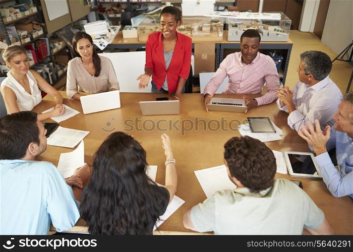 Architects Sitting At Table Meeting With Laptops And Tablets