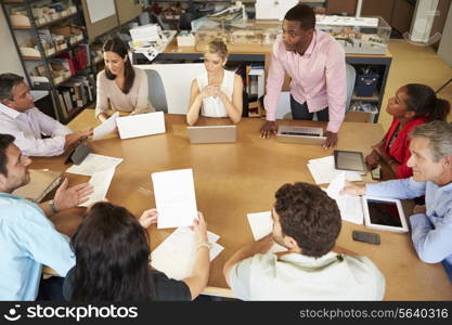 Architects Sitting At Table Meeting With Laptops And Tablets