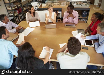 Architects Sitting At Table Meeting With Laptops And Tablets