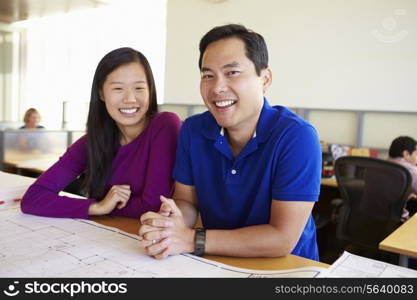 Architects Studying Plans In Modern Office Together