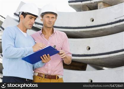 Architects with clipboard working at construction site