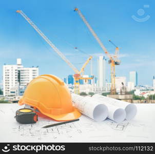 architectural blueprint with safety helmet and tools over
