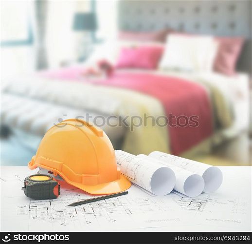 architectural blueprint with safety helmet and tools over bedroom with red scheme color decoration