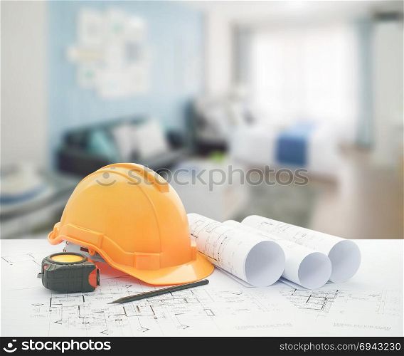 architectural blueprint with safety helmet and tools over blue color scheme bedroom with sofa