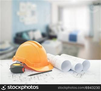 architectural blueprint with safety helmet and tools over blue color scheme bedroom with sofa