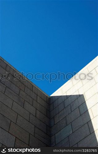 Architectural brick wall with blue sky.