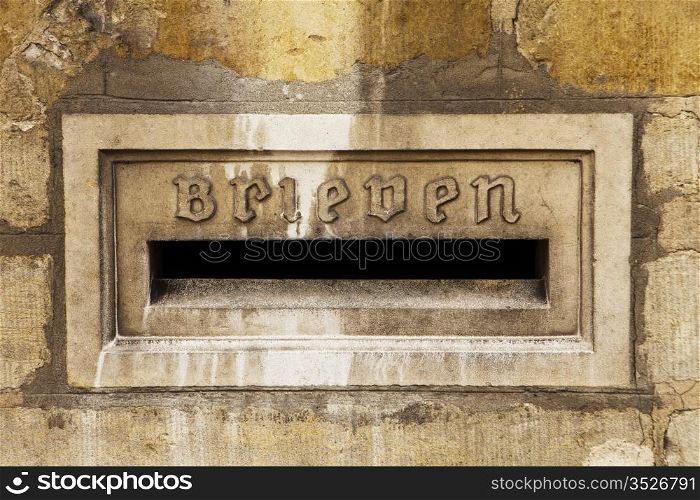 Architectural detail of a letter slot for letters, or brieven, is located on the exterior stone wall of the town hall in the city of Bruges in Belgium.