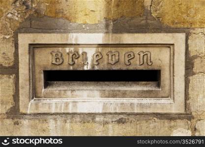 Architectural detail of a letter slot for letters, or brieven, is located on the exterior stone wall of the town hall in the city of Bruges in Belgium.