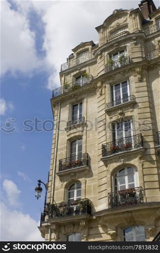 Architectural details of an Art Nouveau facade of a building on Ile de La CitZ, with it&rsquo;s balconies, archetypal street light, chimneys and classical style