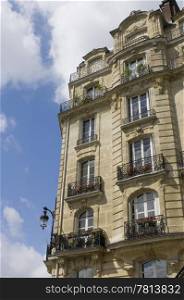 Architectural details of an Art Nouveau facade of a building on Ile de La CitZ, with it&rsquo;s balconies, archetypal street light, chimneys and classical style