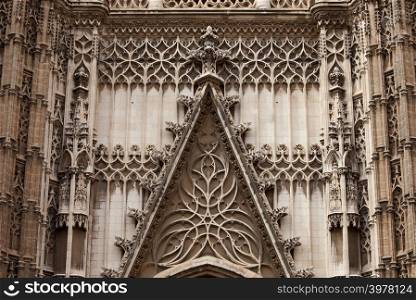 Architectural details of the 15-16th century Gothic Cathedral of Seville in Spain, exterior ornamentation above entrance door.