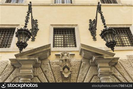 Architectural details of the arched doorway of old street lamps with oil, Udine, Friuli, Italy