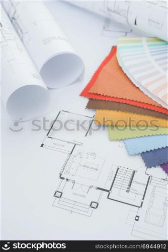 Architectural drawing with color palette , fabric sample and a roll of paper