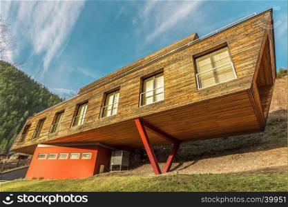 Architectural image with a house clad with planks and in the same time having a modern design.