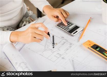 Architectural project workplace. Engineer sketching construction project, Architect drawing with divider compass on house plan blueprint paper for repair tools on table desk at architecture office