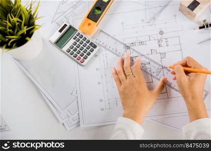Architectural project workspace. Top view of architect drawing with ruler on house plan blueprint paper for repair tools on table desk at architecture office, architect sketching construction project