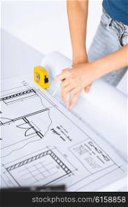 architecture and home renovation concept - architect drawing on blueprint using flexible ruler. architect drawing on blueprint