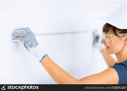 architecture and home renovation concept - female architect measuring wall with flexible ruller. architect measuring wall with flexible ruller