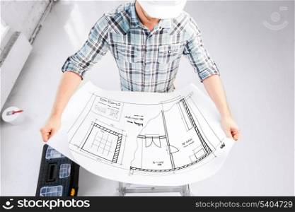 architecture and renovation concept - male architect in helmet with blueprint